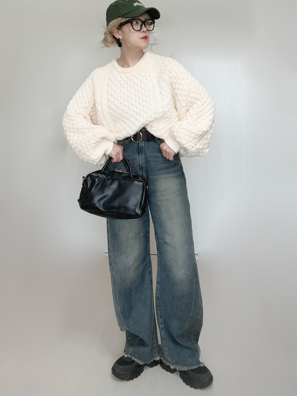 ブルー系のデニムパンツ、ホワイト系のニット/セーター、ブラック系のボストンバッグを着用したレディースの秋コーディネートの5枚目の写真