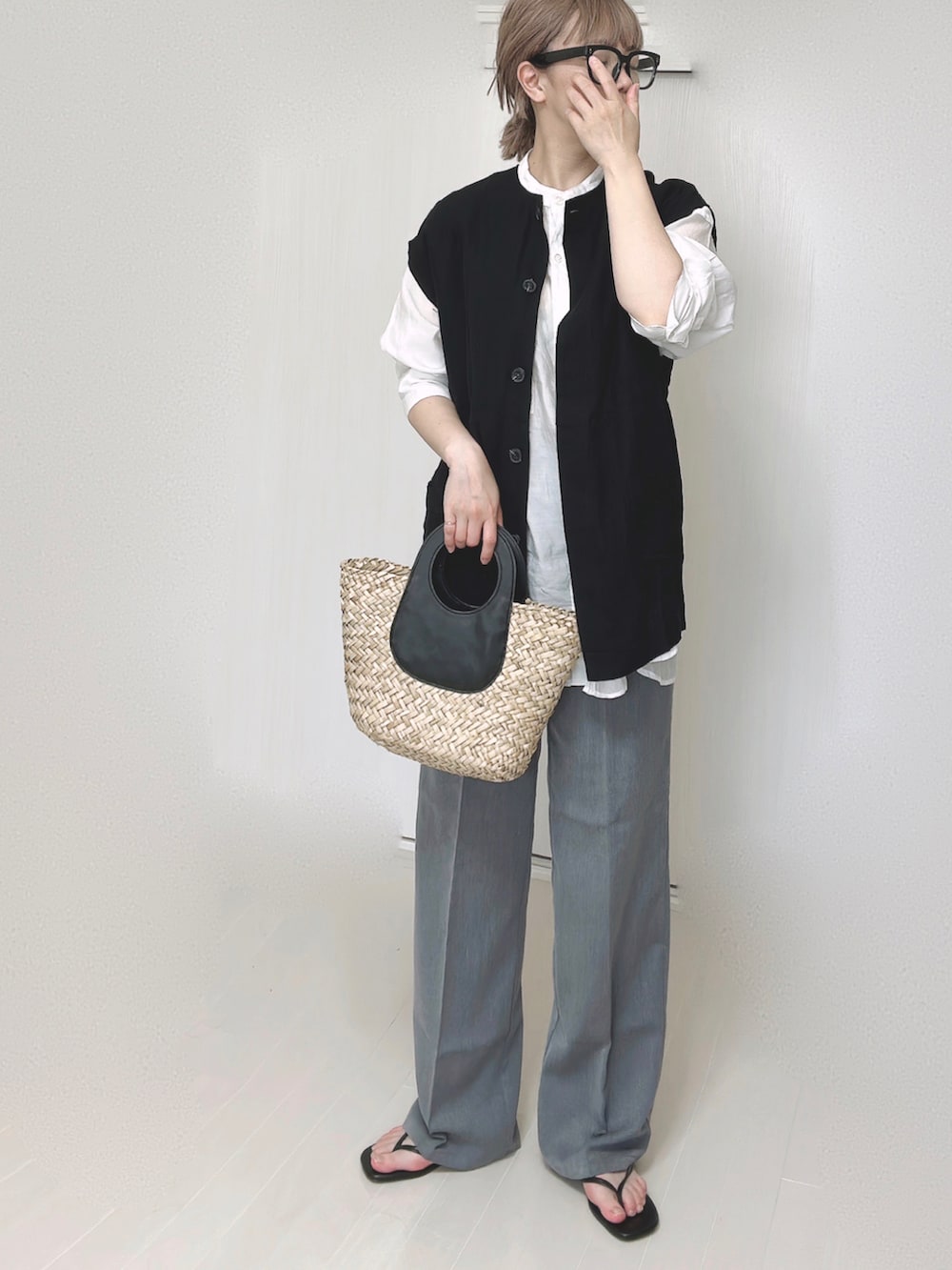 ブラック系のベスト、ホワイト系のシャツ/ブラウス、ブラック系のサンダルを着用したレディースの夏コーディネートの4枚目の写真