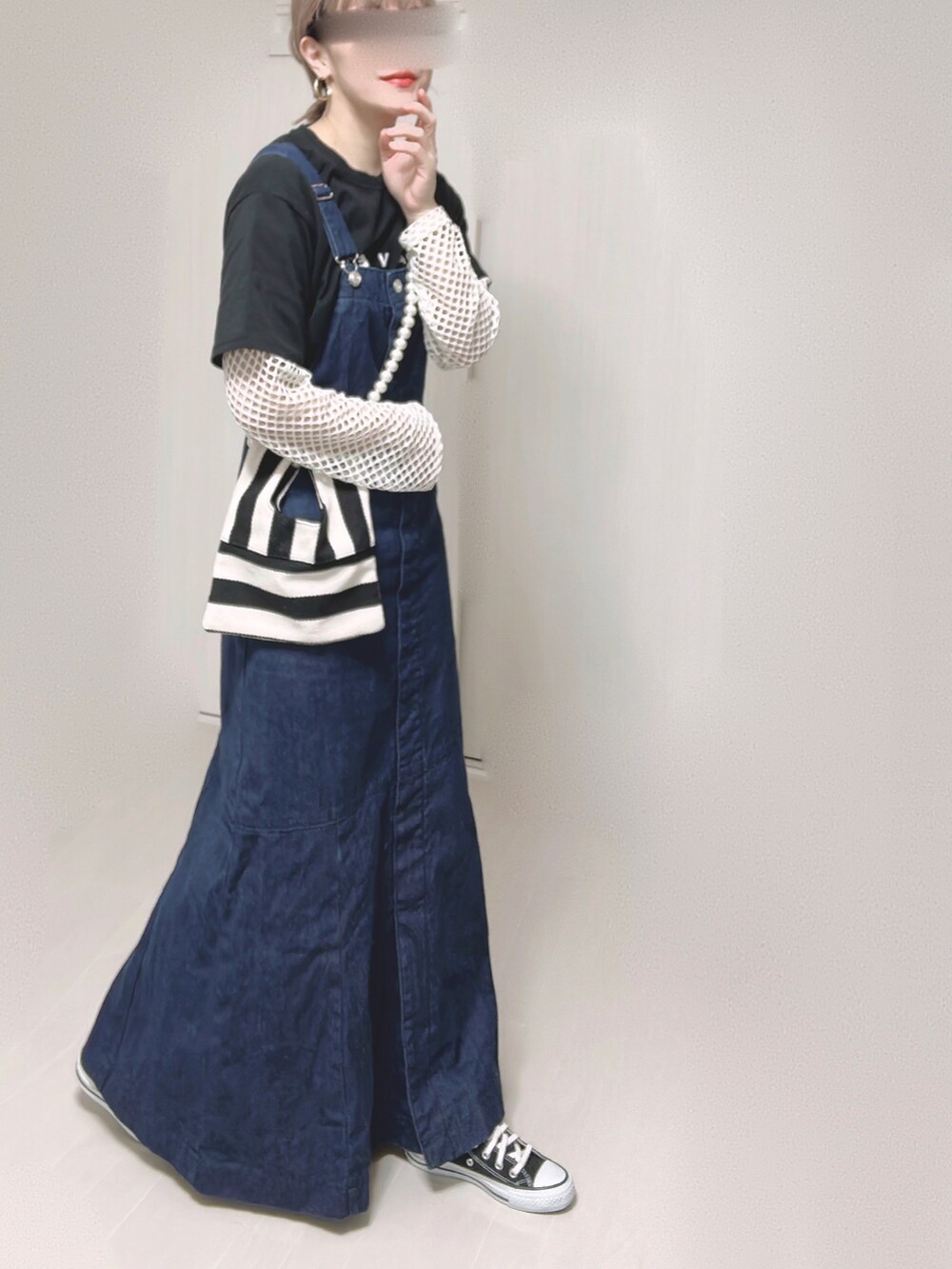 ブルー系のジャンパースカート、ブラック系のTシャツ/カットソー、ホワイト系のショルダーバッグを着用したレディースの春コーディネートの5枚目の写真