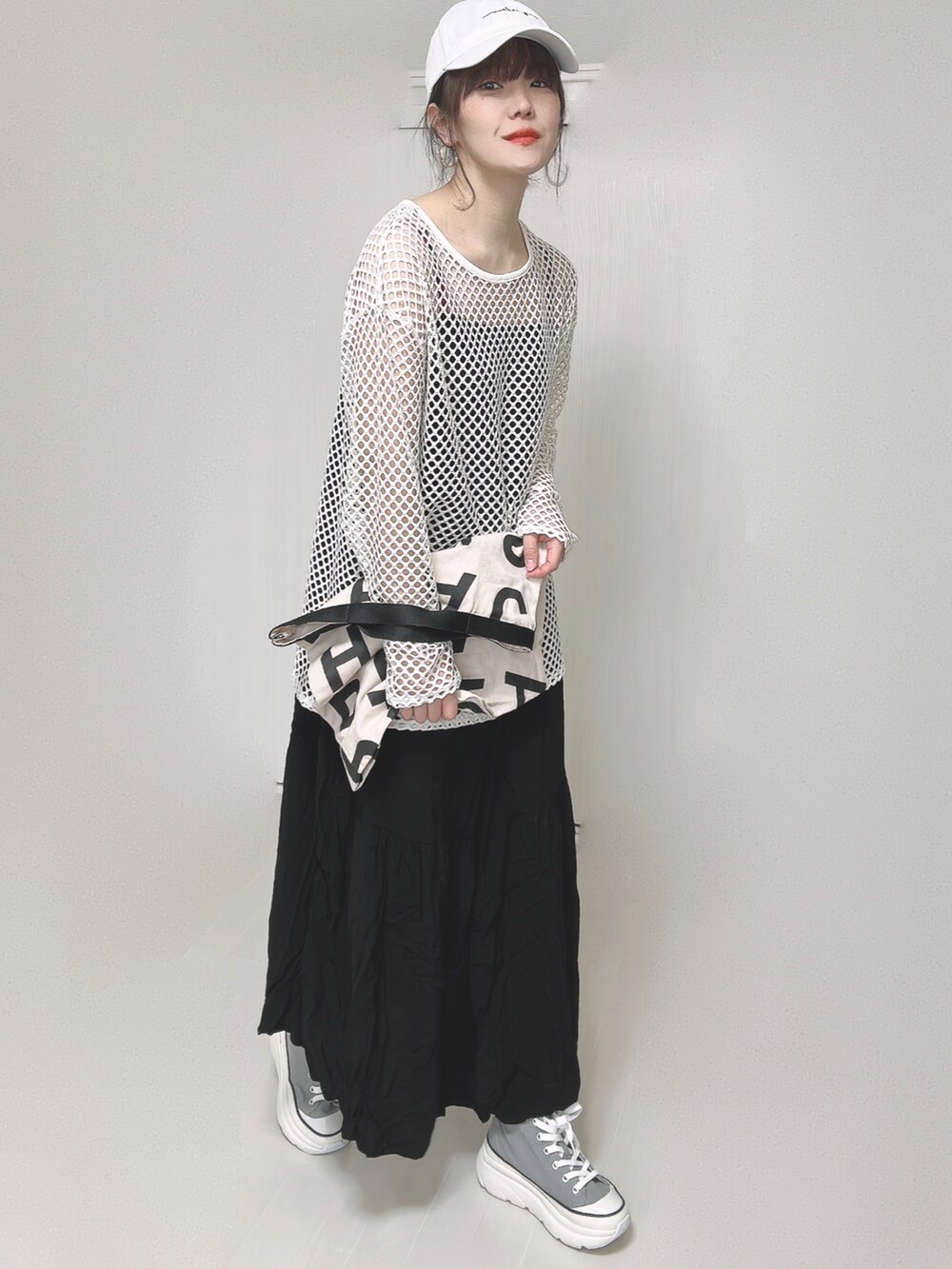 ブラック系のワンピース、ホワイト系のトートバッグ、グレー系のスニーカーを着用したレディースの春コーディネートの4枚目の写真