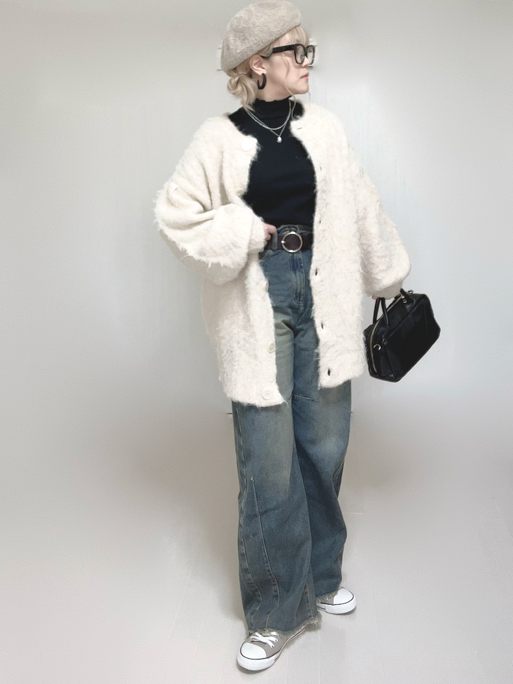 ブラック系のTシャツ/カットソー、ベージュ系のカーディガン/ボレロ、ブラック系のボストンバッグを着用したレディースの秋コーディネートの4枚目の写真