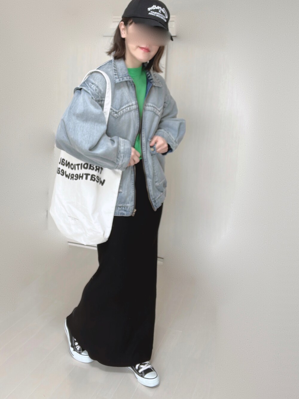 ブルー系のブルゾン、グリーン系のニット/セーター、ホワイト系のトートバッグを着用したレディースの春コーディネートの2枚目の写真