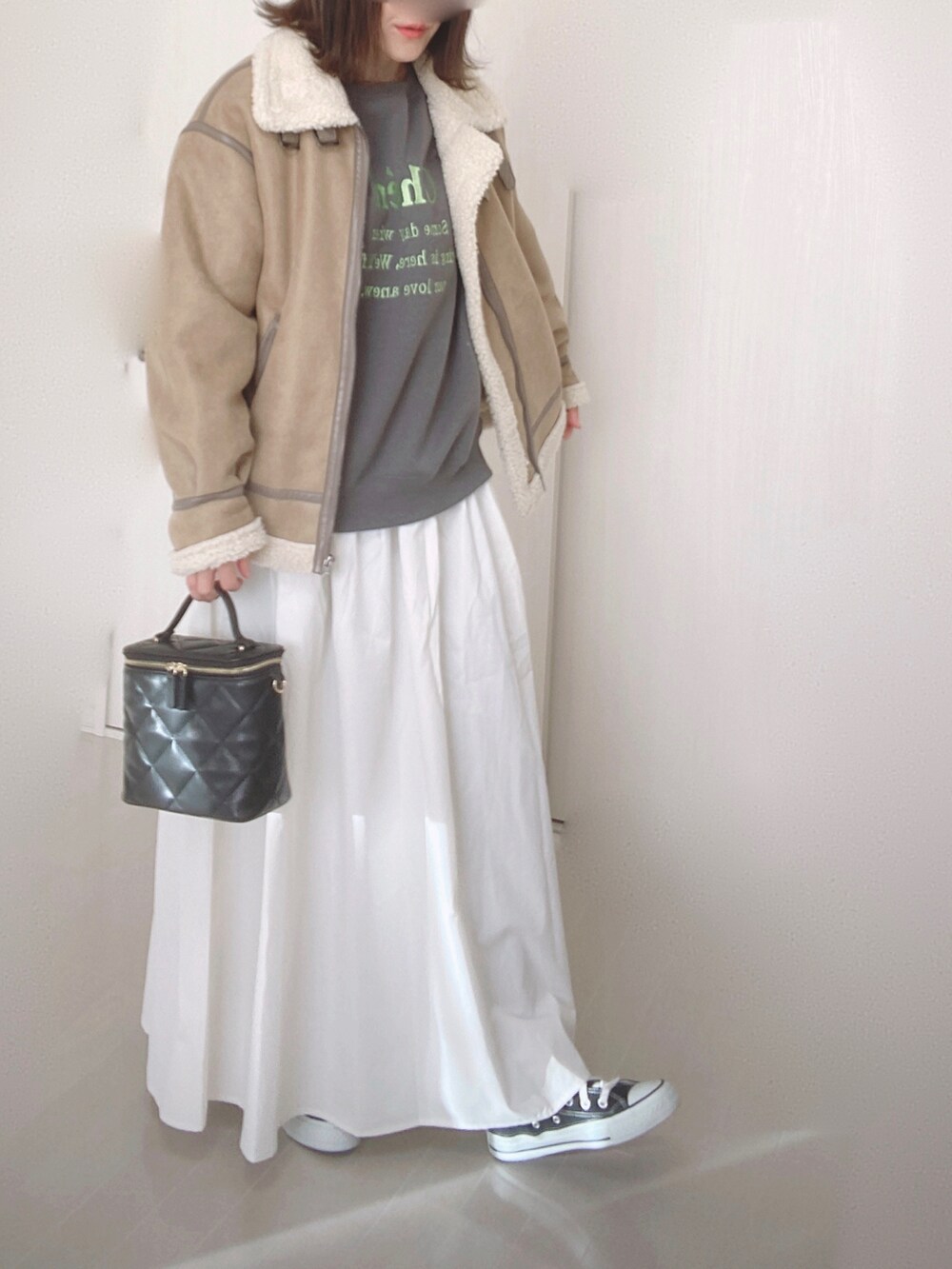 グレー系のスウェット、ホワイト系のスカート、ベージュ系のムートンコートを着用したレディースの冬コーディネートの4枚目の写真