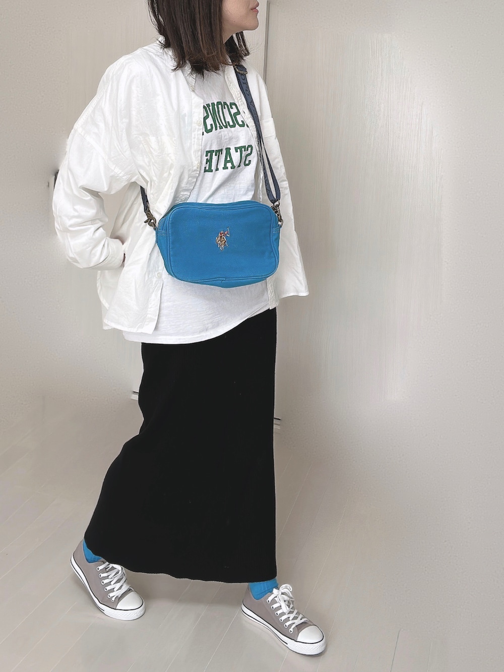 ブルー系のショルダーバッグ、ホワイト系のシャツ/ブラウス、ホワイト系のTシャツ/カットソーを着用したレディースの冬コーディネートの4枚目の写真