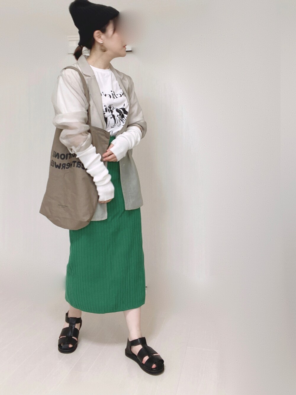 グレー系のテーラードジャケット、ブラウン系のトートバッグ、グリーン系のスカートを着用したレディースの夏コーディネートの4枚目の写真