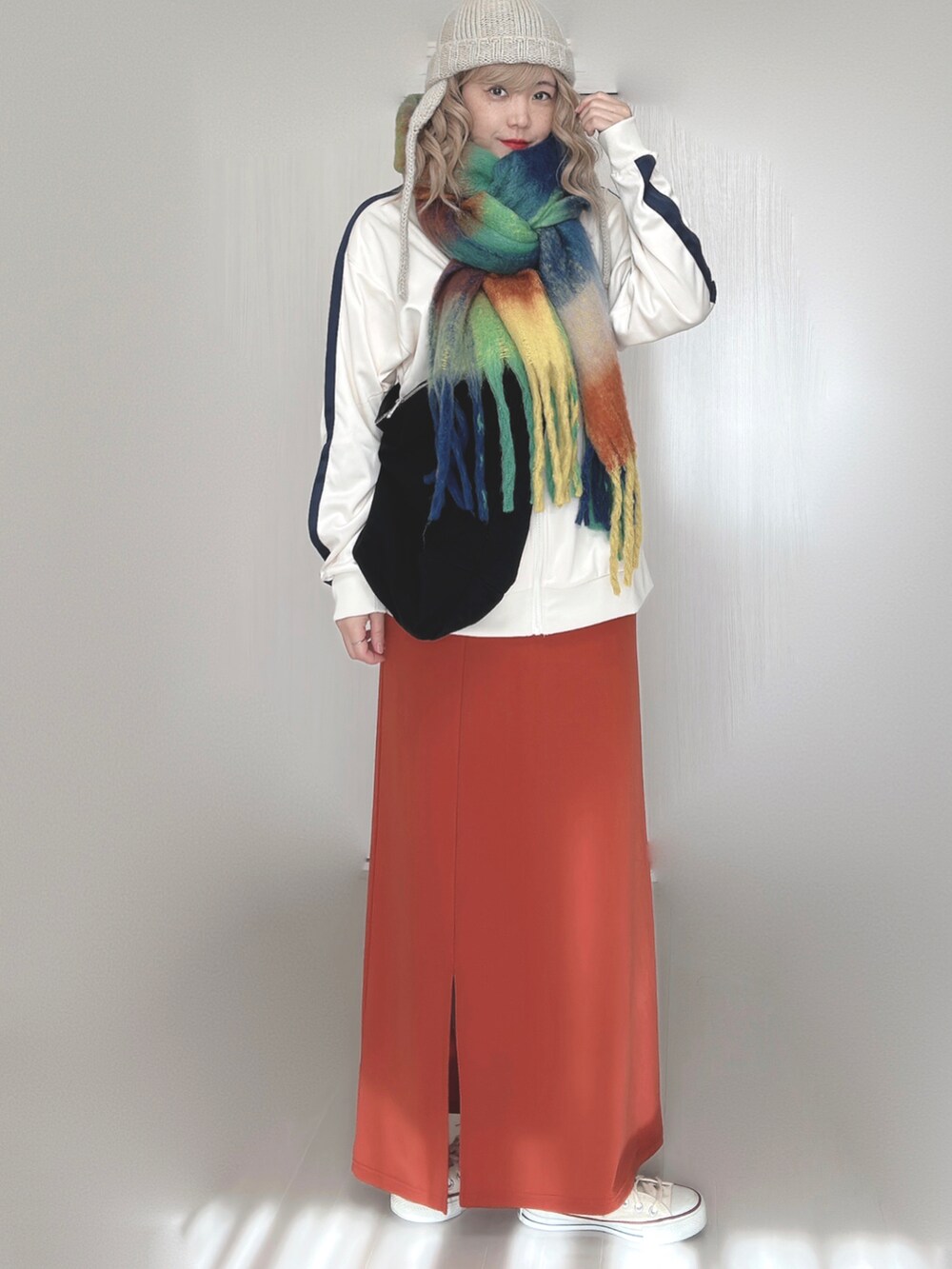 ベージュ系のジャージ、オレンジ系のスカート、ホワイト系のスニーカーを着用したレディースの秋コーディネートの3枚目の写真