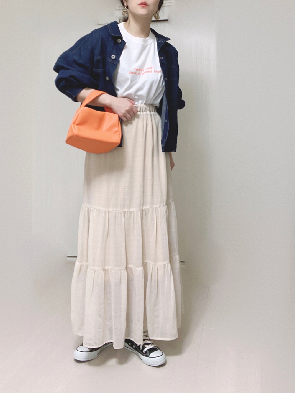 オレンジ系のTシャツ/カットソー、ブルー系のデニムジャケット、オレンジ系のショルダーバッグを着用したレディースの春コーディネートの2枚目の写真