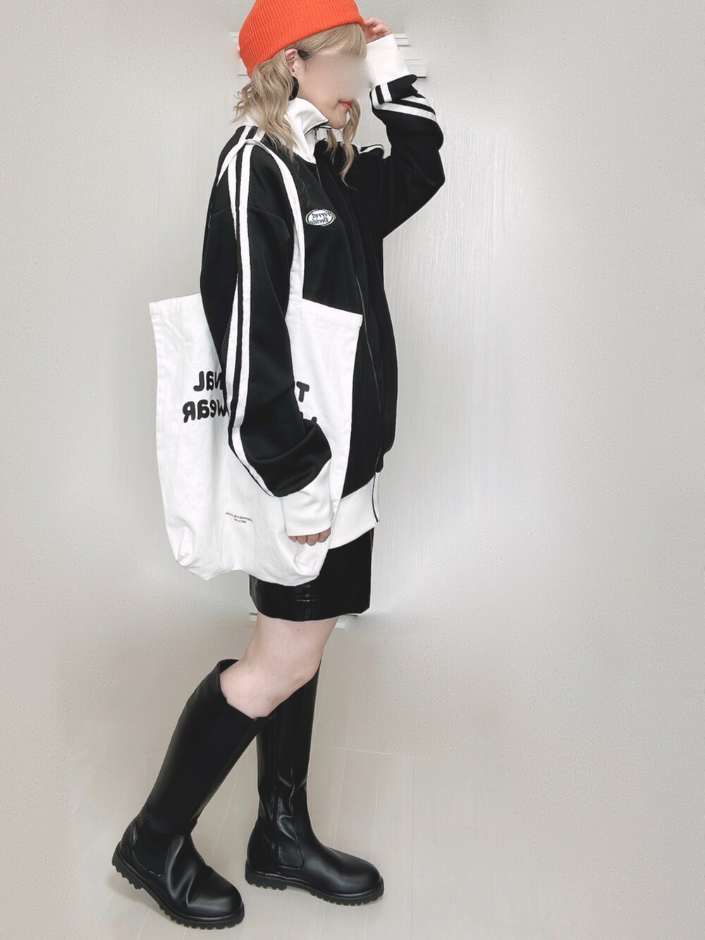 ブラック系のブルゾン、ブルー系のベスト、ホワイト系のトートバッグを着用したレディースの秋コーディネートの4枚目の写真