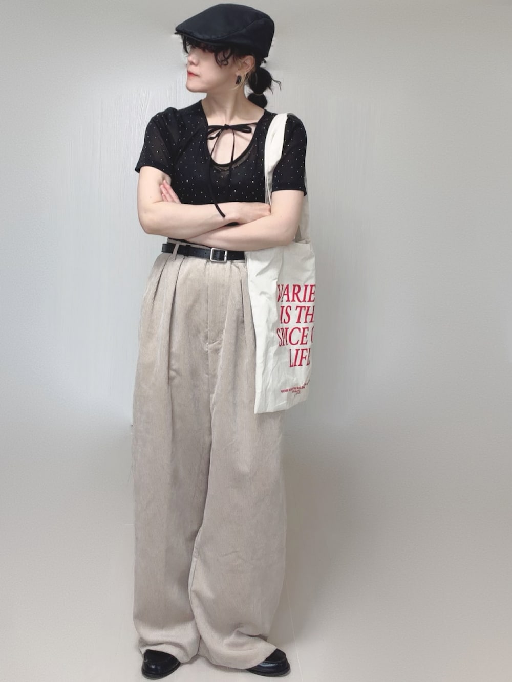 ブラック系のTシャツ/カットソー、ホワイト系のトートバッグ、ベージュ系のスラックスを着用したレディースの夏コーディネートの4枚目の写真