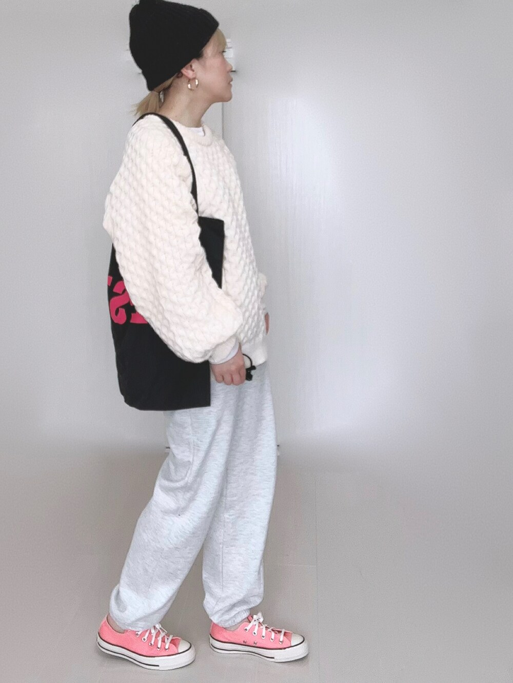 ホワイト系のニット/セーター、ブラック系のトートバッグ、ピンク系のスニーカーを着用したレディースの冬コーディネートの2枚目の写真