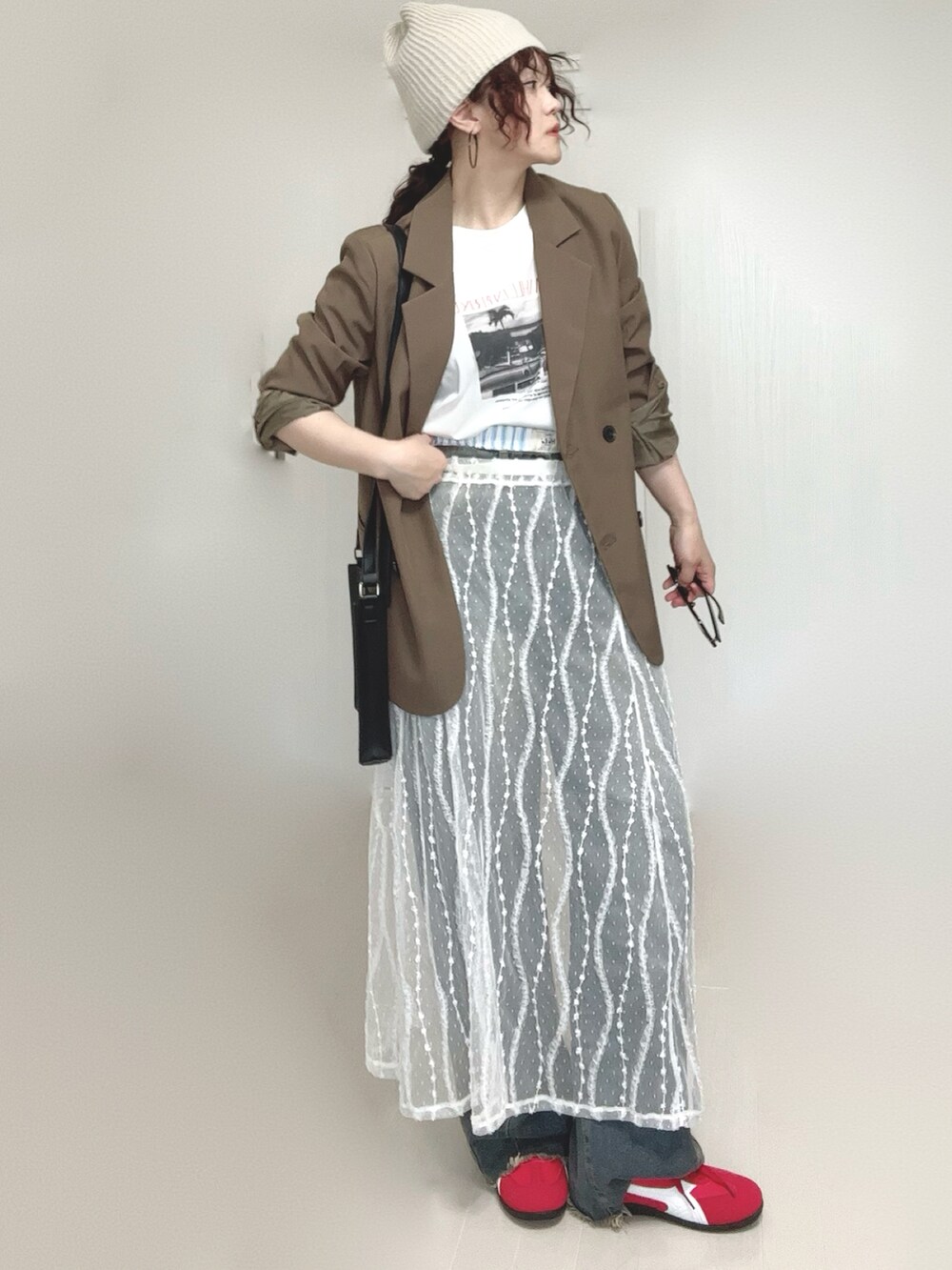 ブラウン系のテーラードジャケット、ブルー系のデニムパンツ、ホワイト系のスカートを着用したレディースの夏コーディネートの4枚目の写真