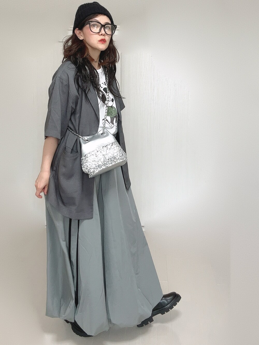 グレー系のテーラードジャケット、ブラック系のブーツ、ホワイト系のTシャツ/カットソーを着用したレディースの夏コーディネートの3枚目の写真