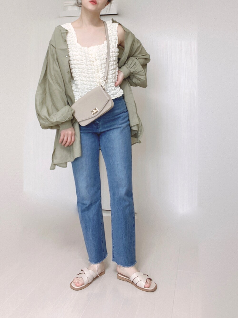 ホワイト系のサンダル、グリーン系のシャツ/ブラウス、ブルー系のデニムパンツを着用したレディースの春コーディネートの3枚目の写真