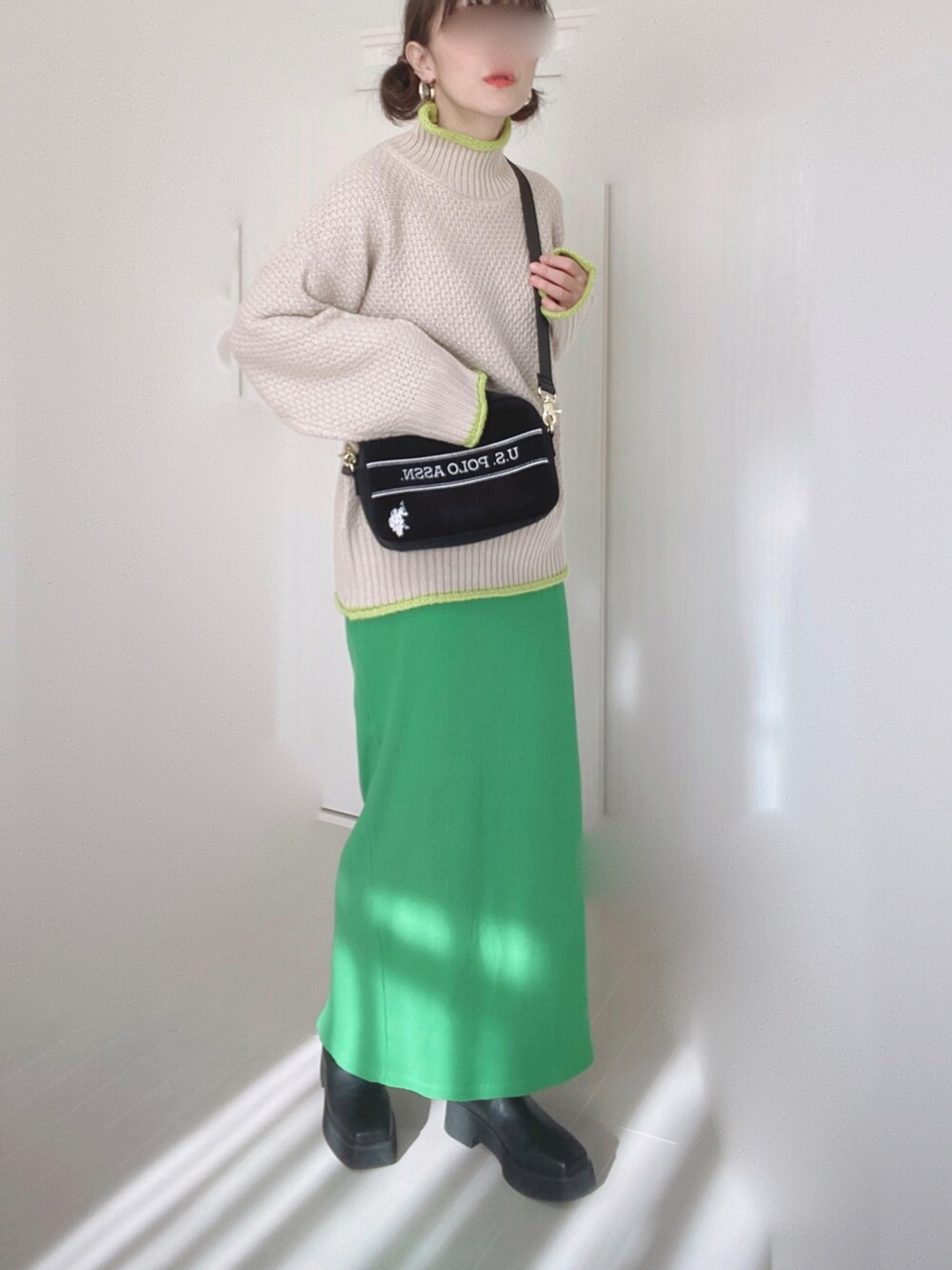 ブラック系のショルダーバッグ、ホワイト系のダウンジャケット/コート、ベージュ系のニット/セーターを着用したレディースの冬コーディネートの5枚目の写真