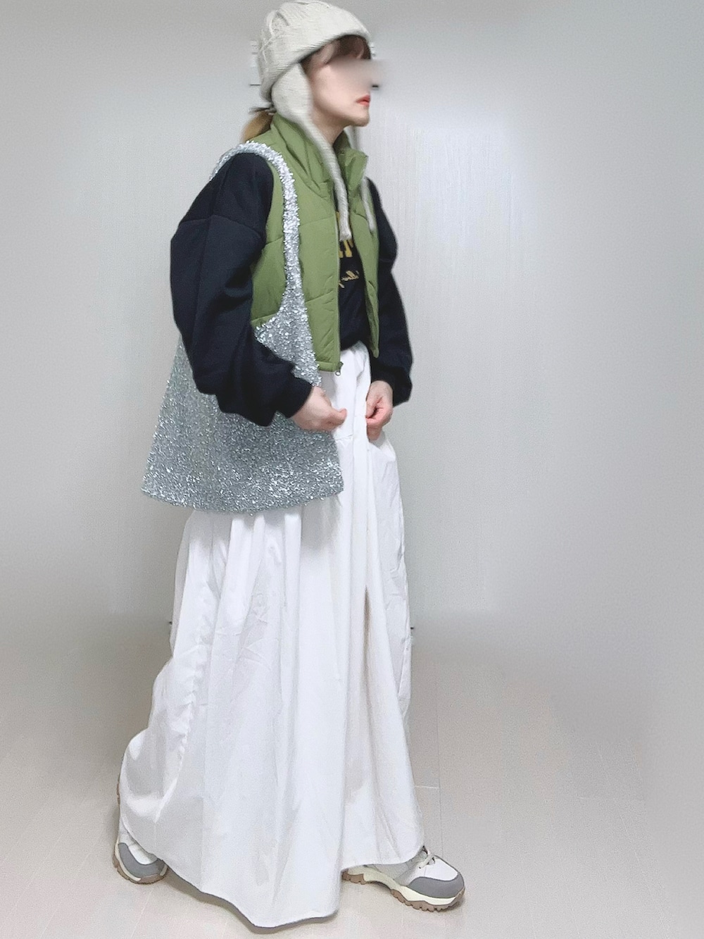 ホワイト系のスカート、ベージュ系のスニーカー、ベージュ系のニットキャップ/ビーニーを着用したレディースの冬コーディネートの5枚目の写真