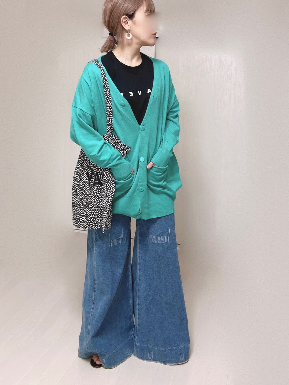 グリーン系のカーディガン/ボレロ、ブラック系のTシャツ/カットソー、ブラック系のサンダルを着用したレディースの春コーディネートの4枚目の写真