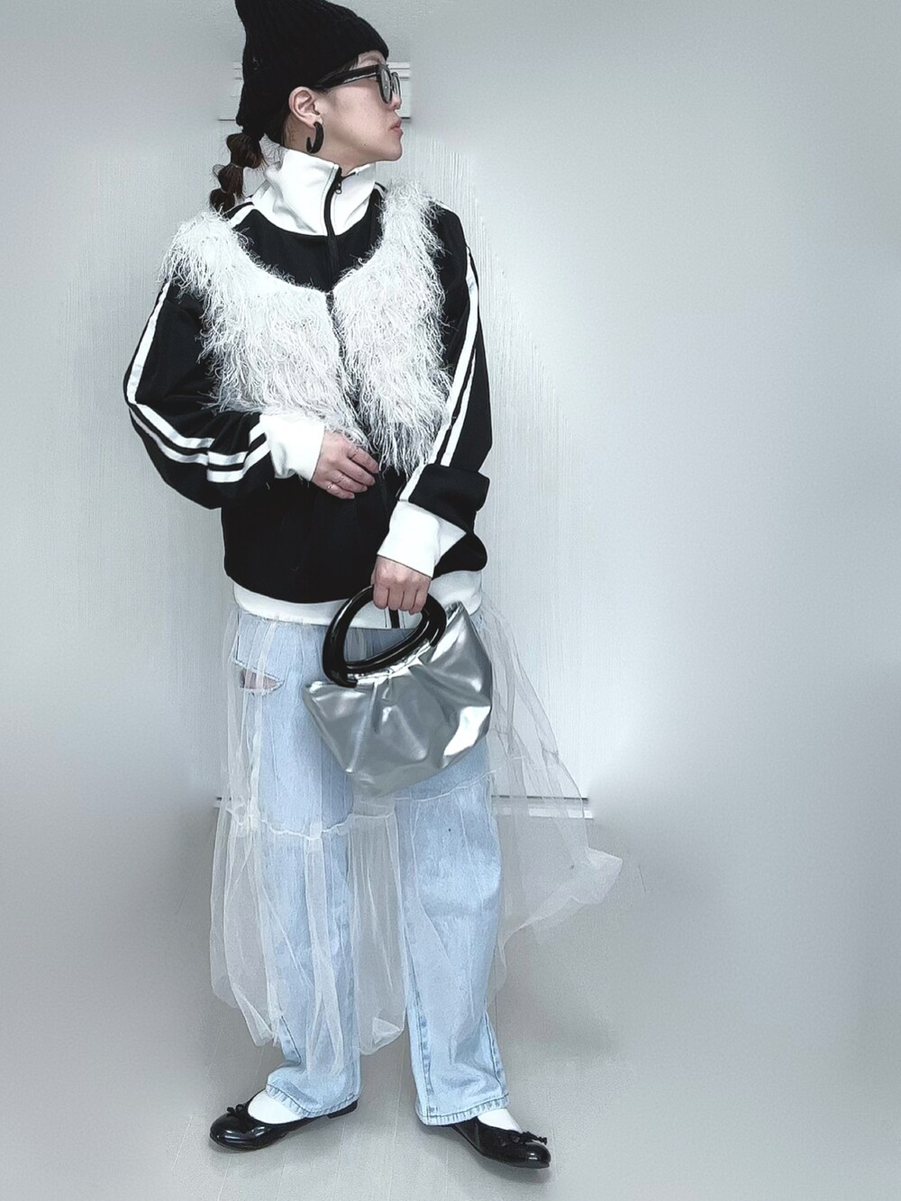 ブラック系のブルゾン、ホワイト系のベスト、ホワイト系のスカートを着用したレディースの春コーディネートの4枚目の写真