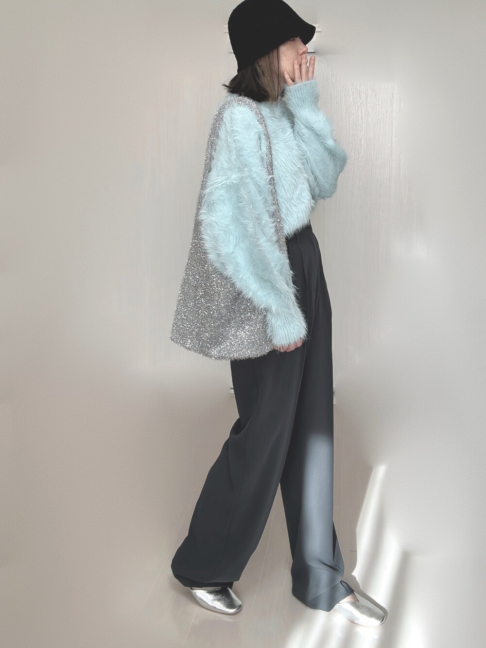 ブルー系のニット/セーター、グレー系のスラックス、シルバー系のパンプスを着用したレディースの秋コーディネートの4枚目の写真