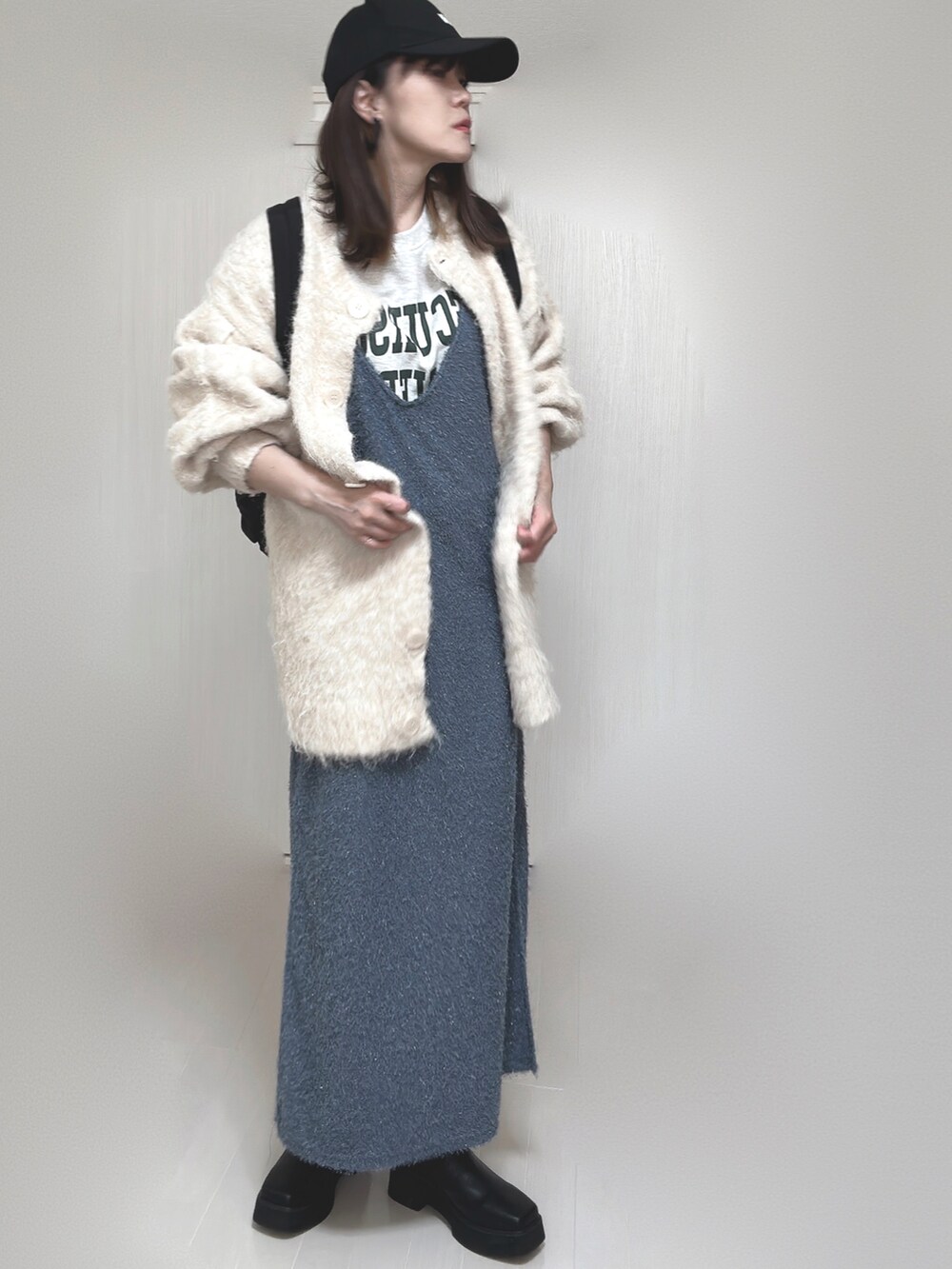 ベージュ系のカーディガン/ボレロ、ブラック系のブーツ、ブラック系のバックパック/リュックを着用したレディースの秋コーディネートの4枚目の写真