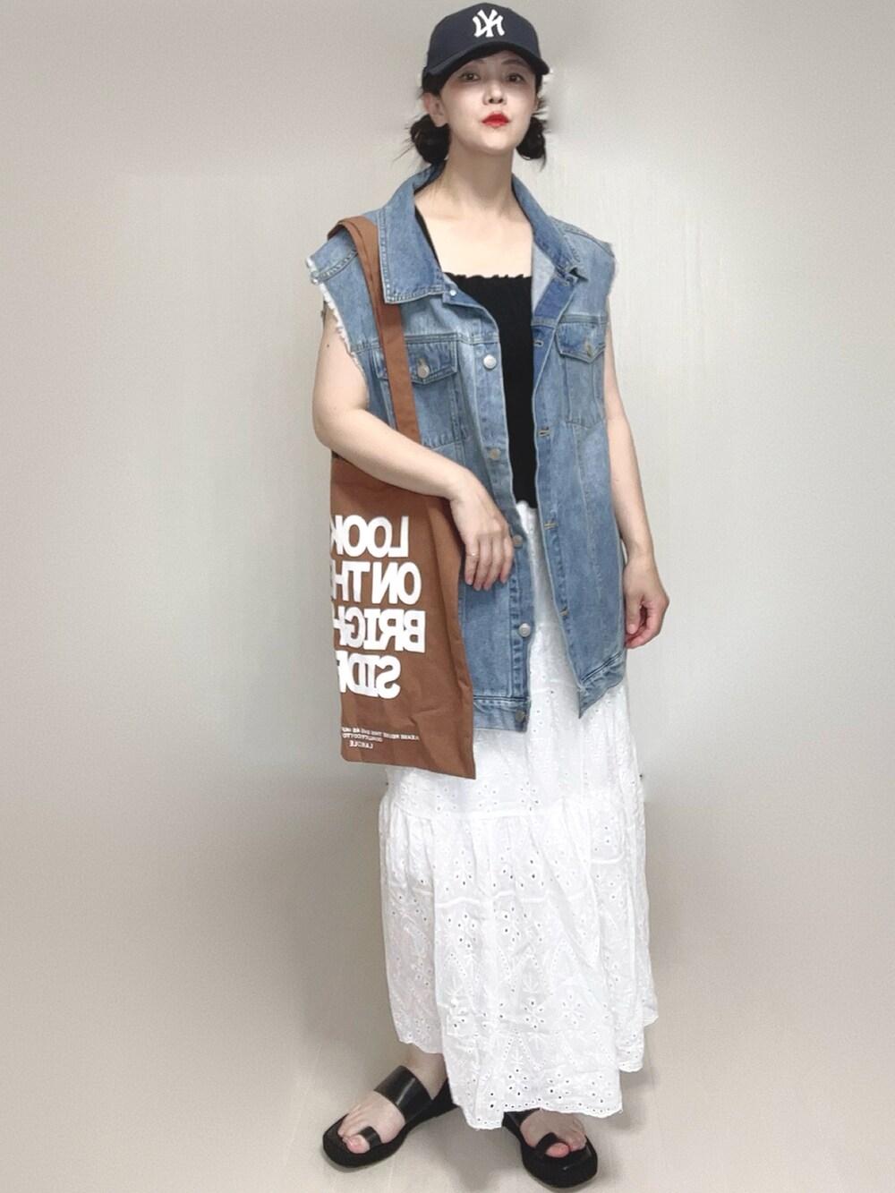 ブラック系のキャミソール、ブラウン系のトートバッグ、ブラック系のサンダルを着用したレディースの夏コーディネートの5枚目の写真