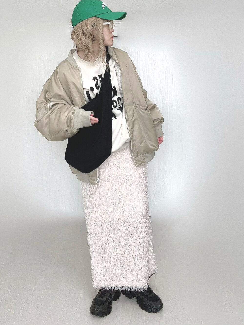 ベージュ系のMA-1、ブラック系のスニーカー、イエロー系のメガネを着用したレディースの春コーディネートの3枚目の写真