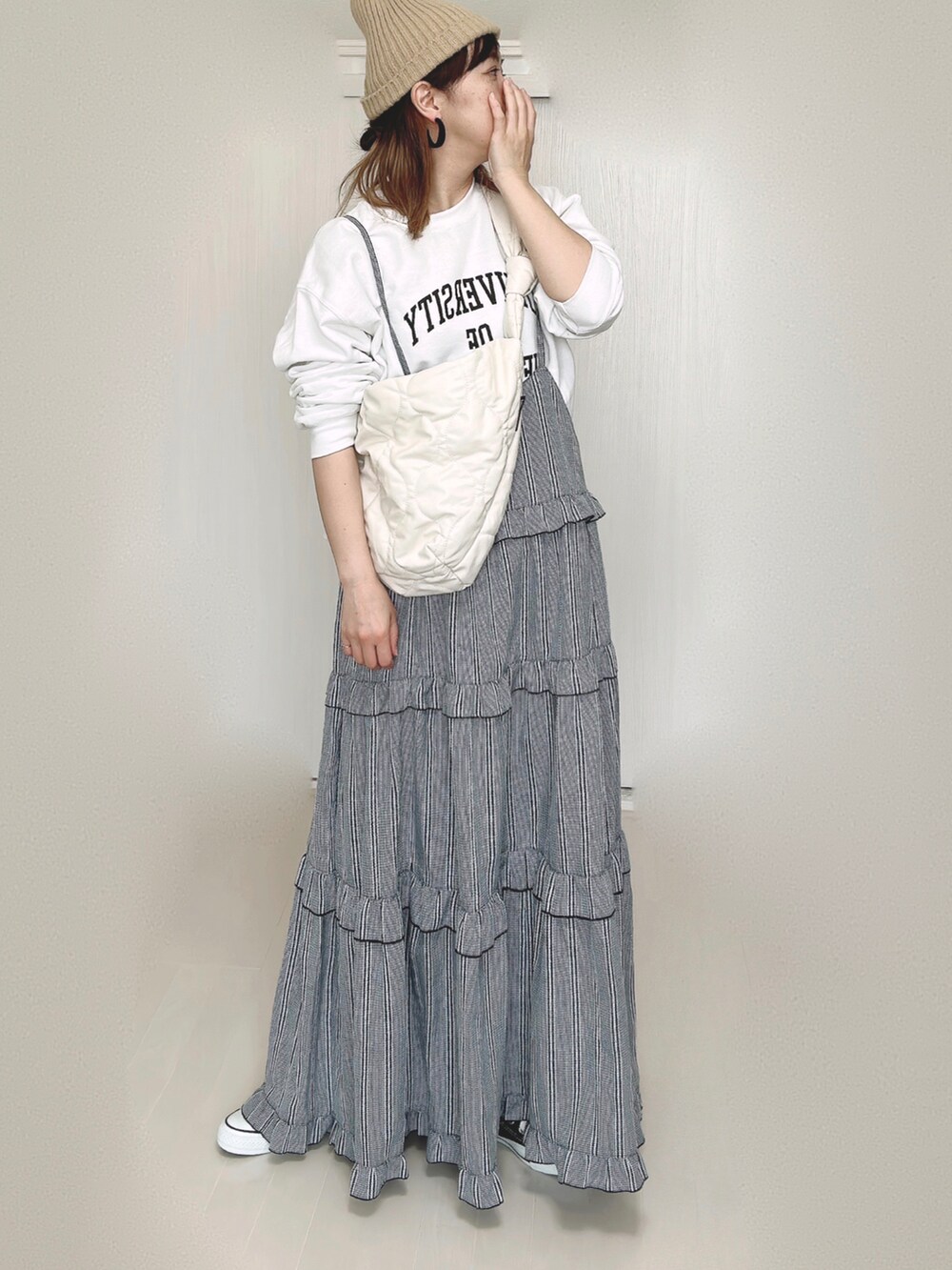 ホワイト系のスウェット、ホワイト系のショルダーバッグ、ブラック系のワンピースを着用したレディースの秋コーディネートの2枚目の写真