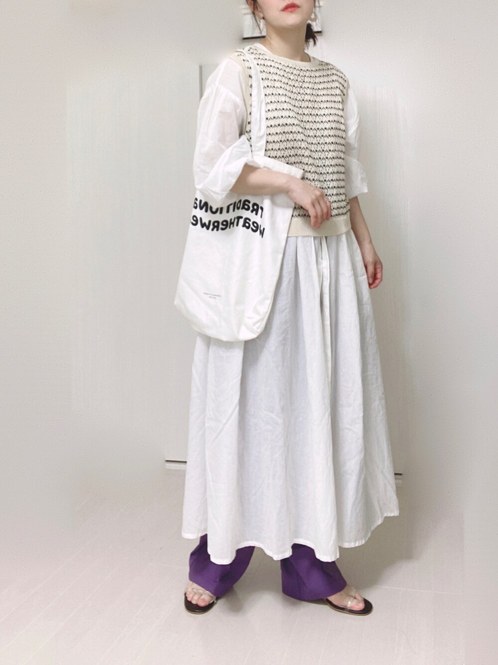 パープル系のスラックス、ホワイト系のシャツワンピース、ホワイト系のトートバッグを着用したレディースの秋コーディネートの3枚目の写真