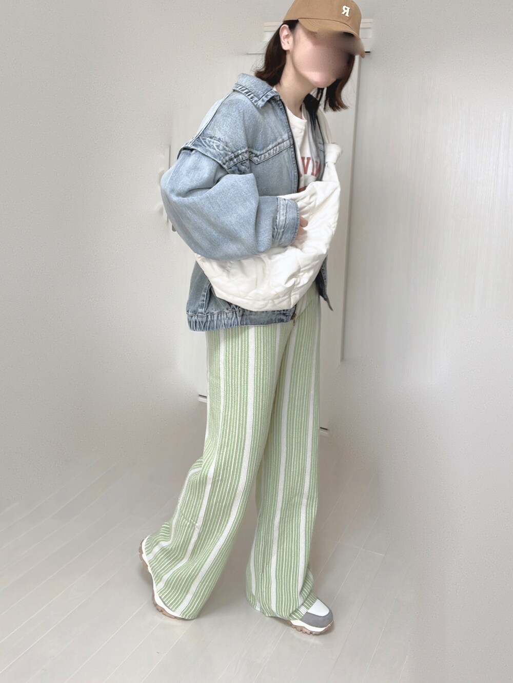 ブルー系のブルゾン、ホワイト系のショルダーバッグ、グリーン系のその他パンツを着用したレディースの春コーディネートの4枚目の写真