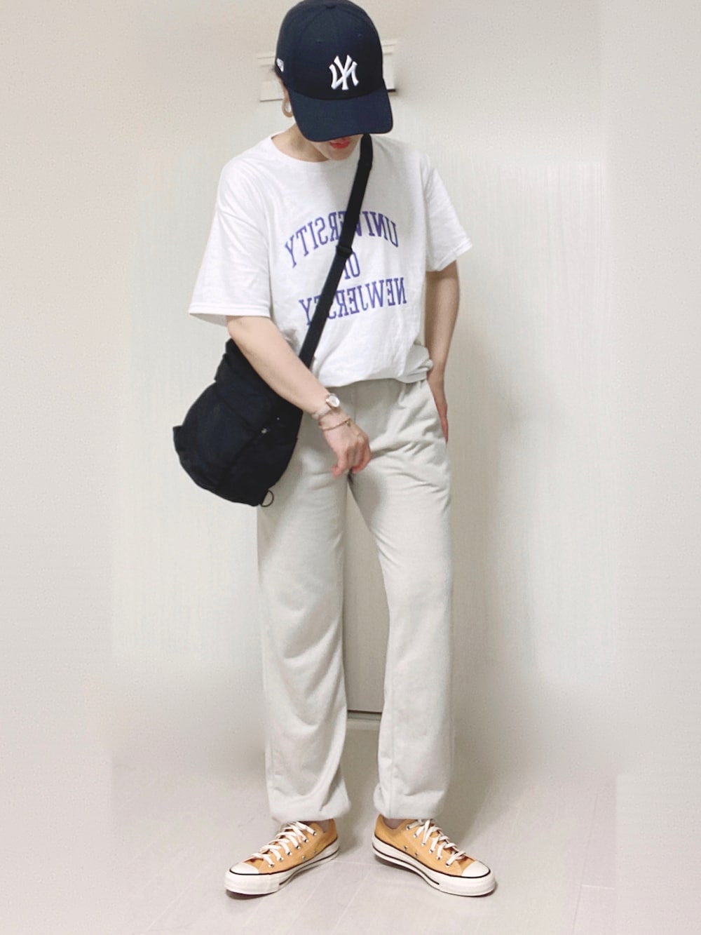 ホワイト系のTシャツ/カットソー、ブラック系のショルダーバッグ、ベージュ系のアナログ腕時計を着用したレディースの夏コーディネートの2枚目の写真