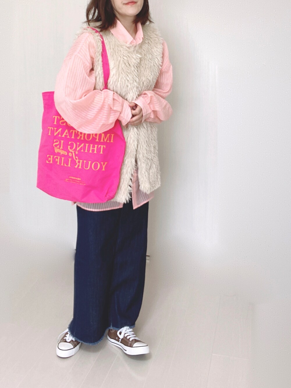 ホワイト系のベスト、ピンク系のシャツ/ブラウス、ブルー系のデニムスカートを着用したレディースの秋コーディネートの4枚目の写真