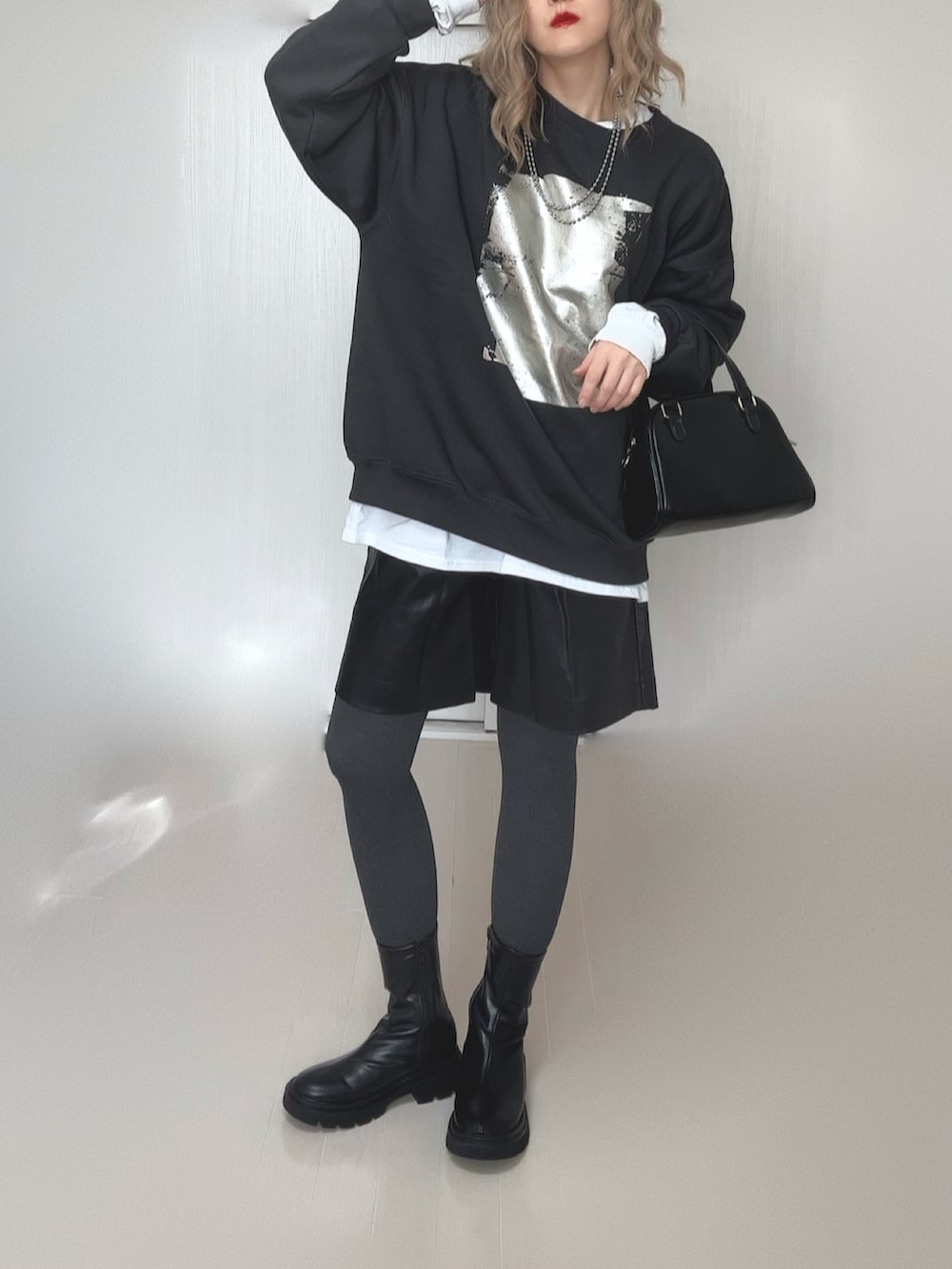 ホワイト系のTシャツ/カットソー、ブラック系のブーツ、ブラック系のスウェットを着用したレディースの冬コーディネートの5枚目の写真