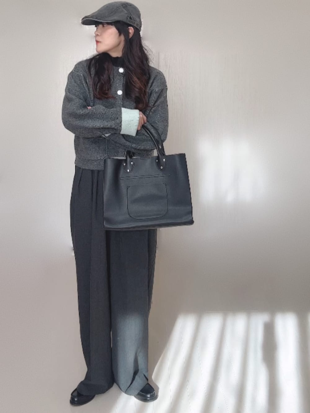 グレー系のカーディガン/ボレロ、ブラック系のローファー、グレー系のスラックスを着用したレディースの冬コーディネートの2枚目の写真