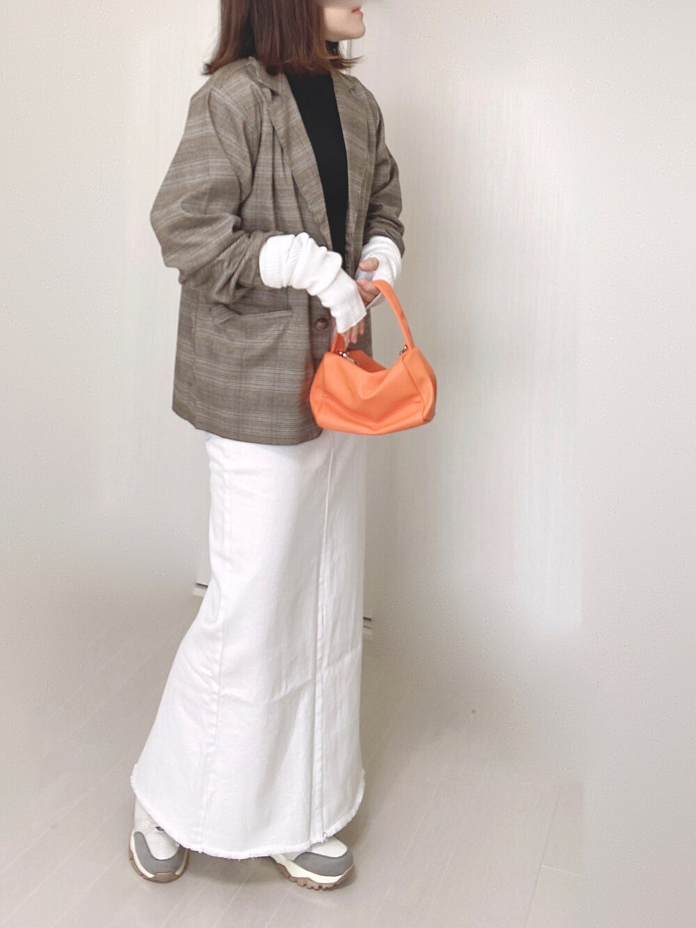 ベージュ系のデニムスカート、ブラウン系のテーラードジャケット、オレンジ系のショルダーバッグを着用したレディースの秋コーディネートの2枚目の写真