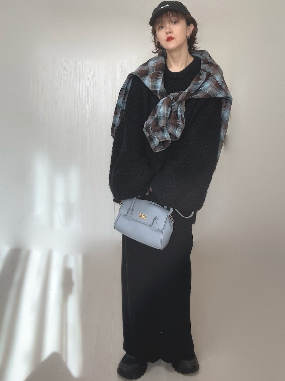 ブラウン系のシャツ/ブラウス、ブラック系のニット/セーター、ブラック系のスカートを着用したレディースの冬コーディネートの4枚目の写真