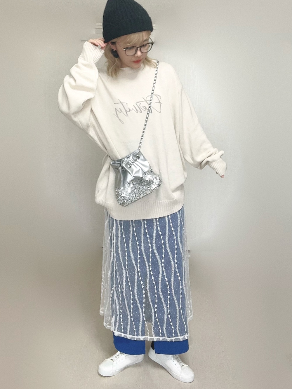 ホワイト系のニット/セーター、シルバー系のショルダーバッグ、ホワイト系のスカートを着用したレディースの秋コーディネートの2枚目の写真
