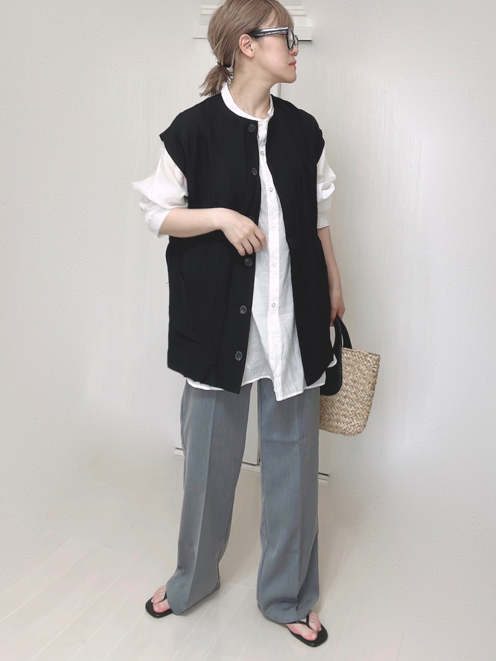 ブラック系のベスト、ホワイト系のシャツ/ブラウス、ブラック系のサンダルを着用したレディースの夏コーディネートの3枚目の写真