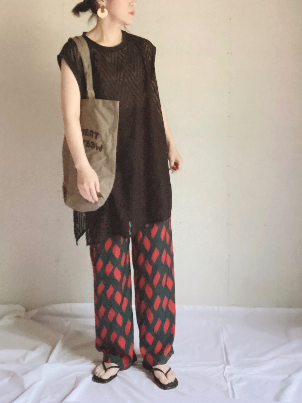 グリーン系のその他パンツ、ブラック系のベスト、ブラウン系のトートバッグを着用したレディースの夏コーディネートの5枚目の写真