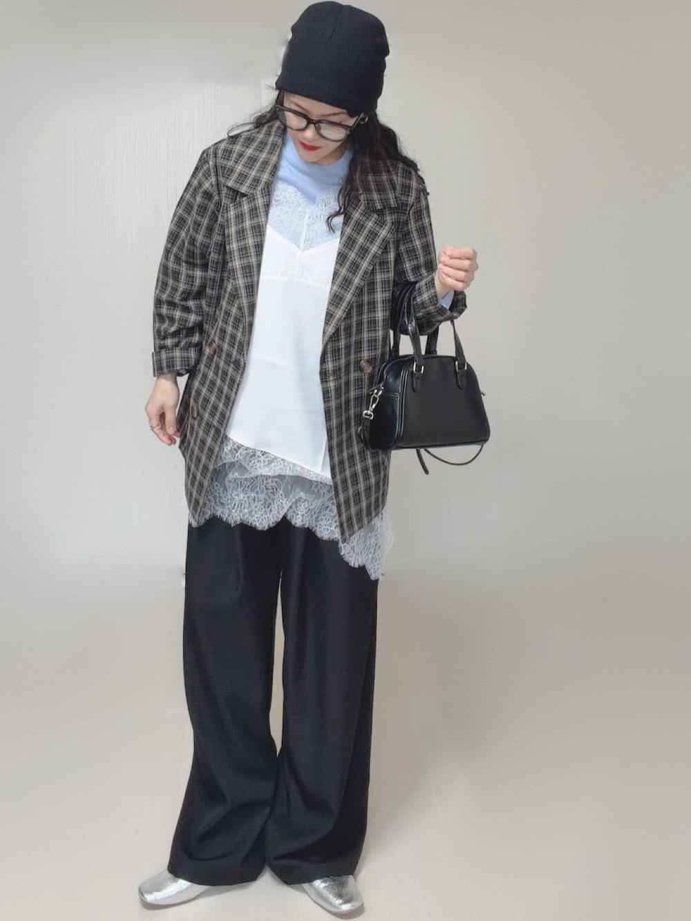 ホワイト系のキャミソール、シルバー系のパンプス、ブラック系のテーラードジャケットを着用したレディースの春コーディネートの2枚目の写真