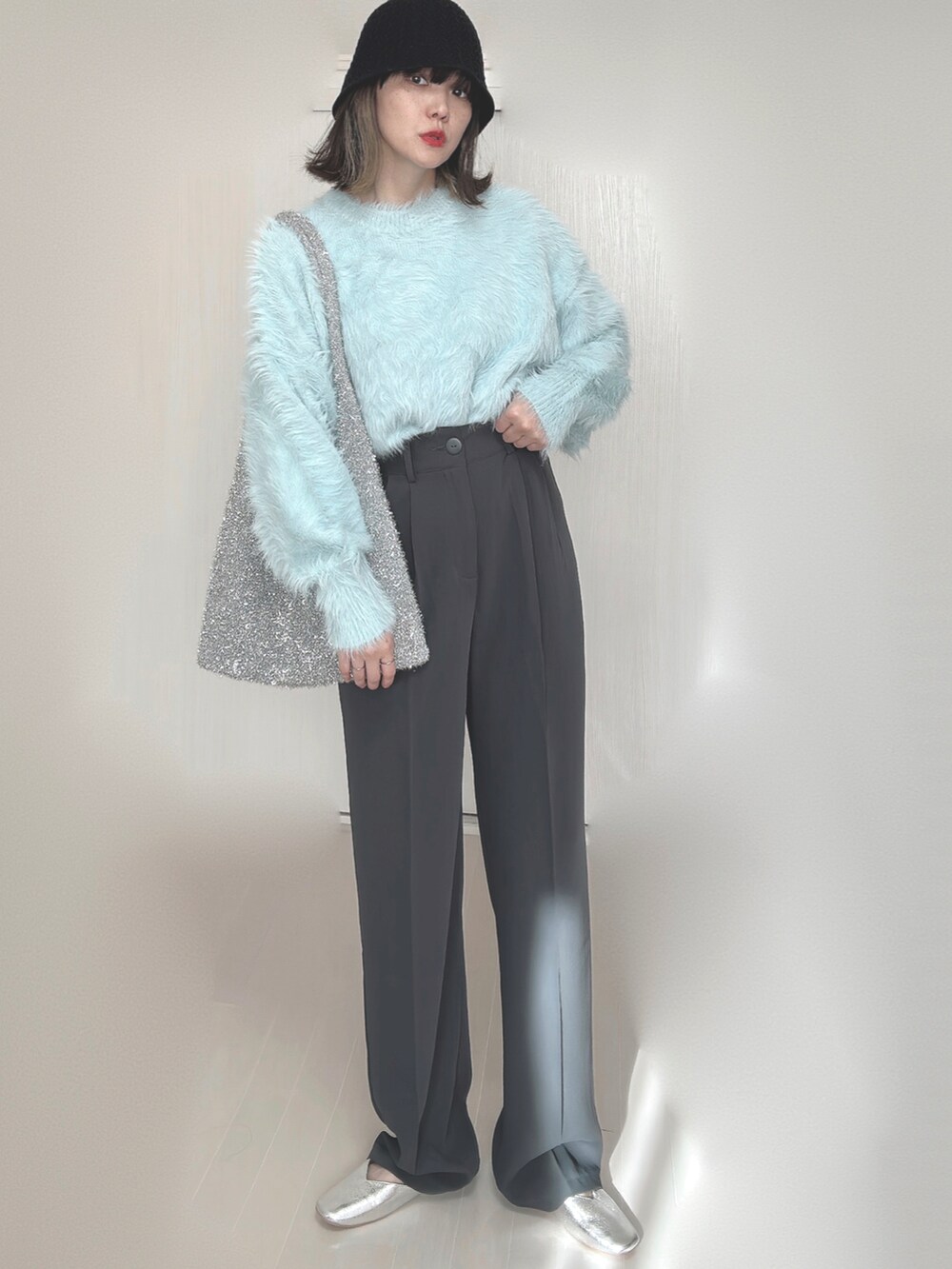 ブルー系のニット/セーター、グレー系のスラックス、シルバー系のパンプスを着用したレディースの秋コーディネートの5枚目の写真