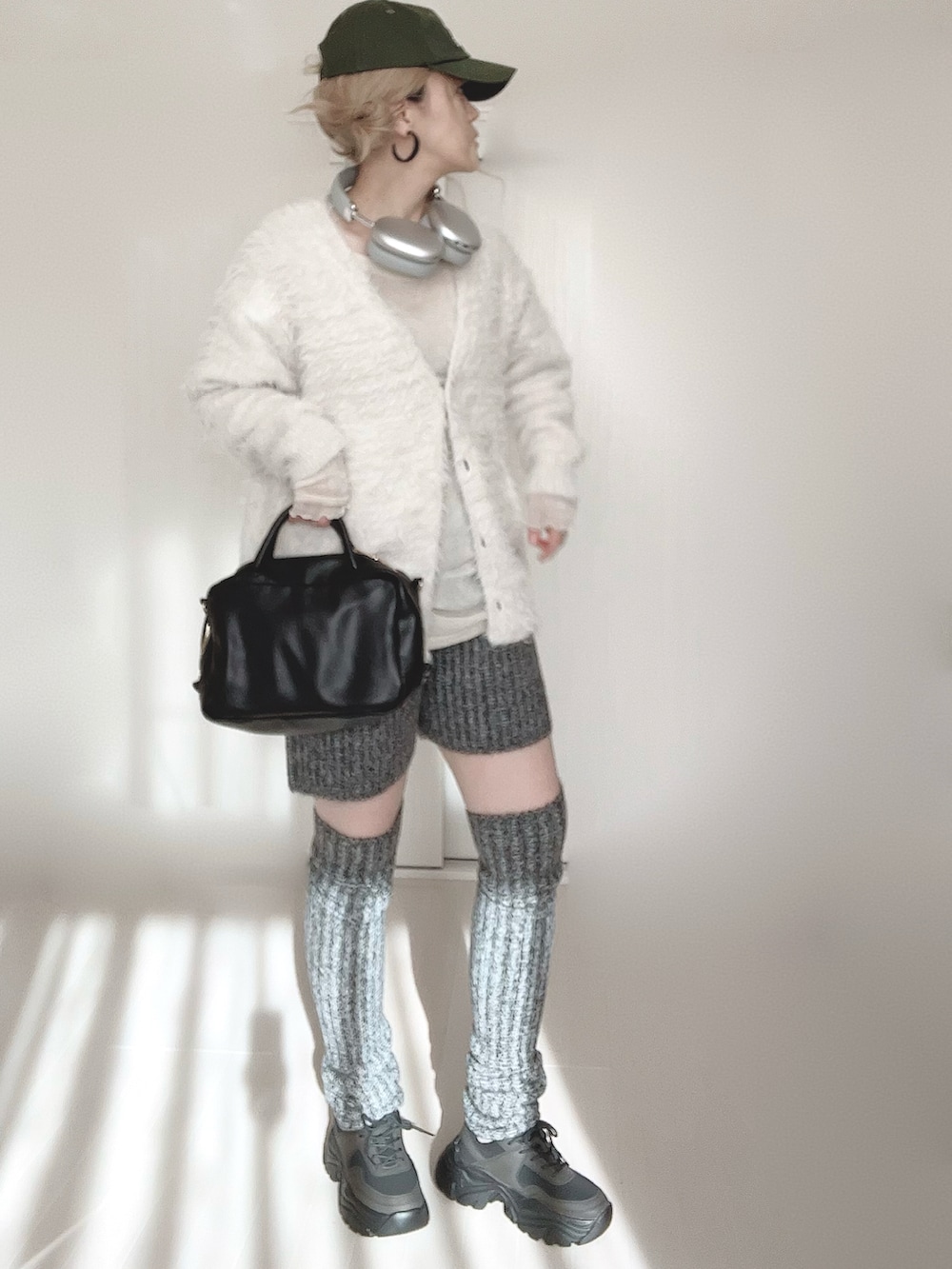 ホワイト系のカーディガン/ボレロ、グレー系のその他パンツ、ブラック系のボストンバッグを着用したレディースの冬コーディネートの2枚目の写真