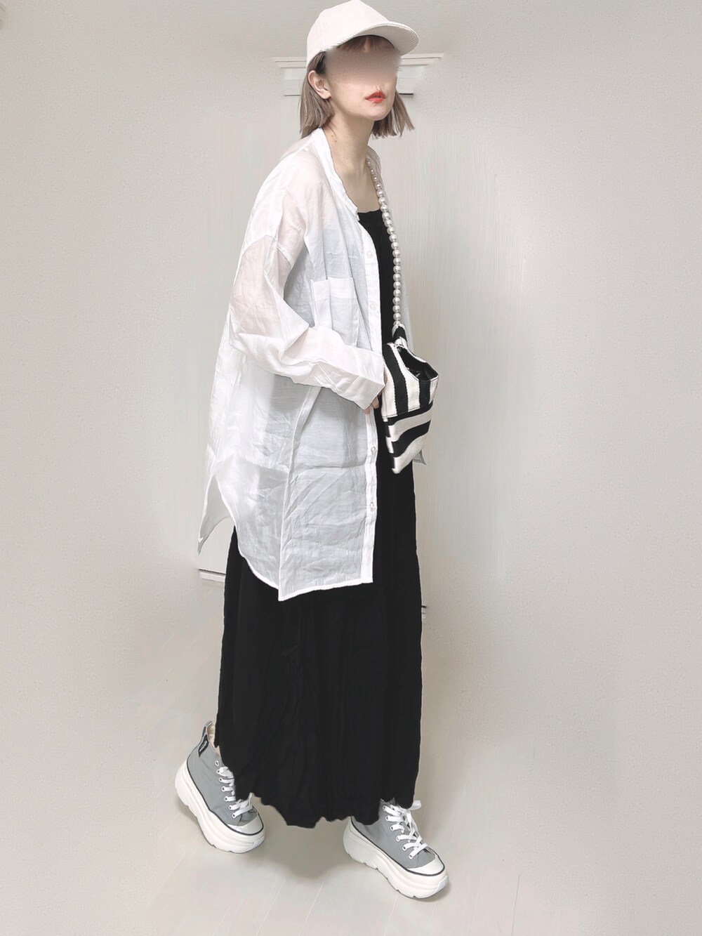 ブラック系のワンピース、ホワイト系のシャツ/ブラウス、ホワイト系のショルダーバッグを着用したレディースの春コーディネートの5枚目の写真