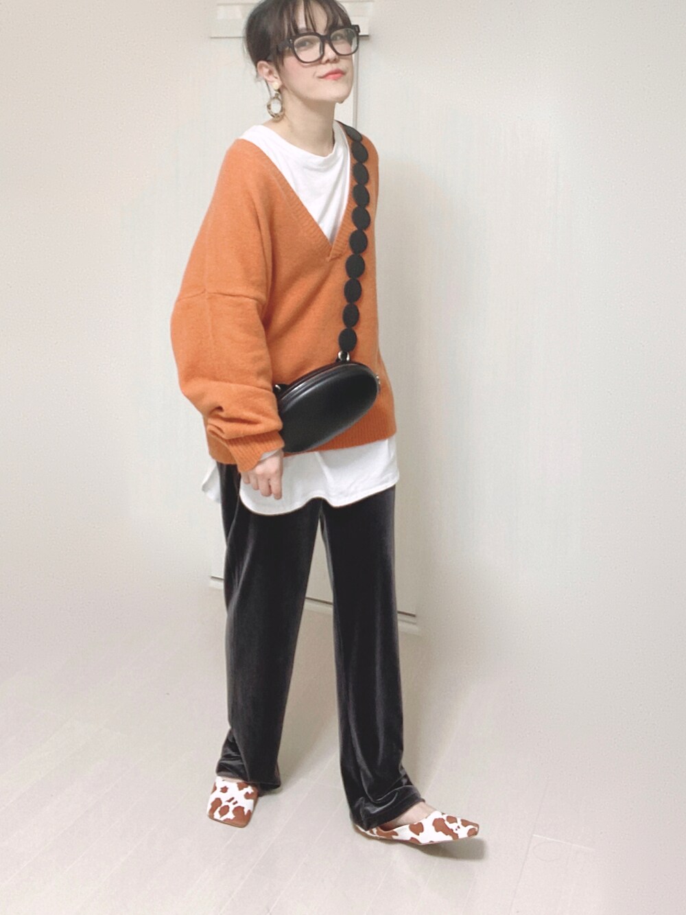 オレンジ系のニット/セーター、グレー系のその他パンツ、イエロー系のパンプスを着用したレディースの秋コーディネートの3枚目の写真