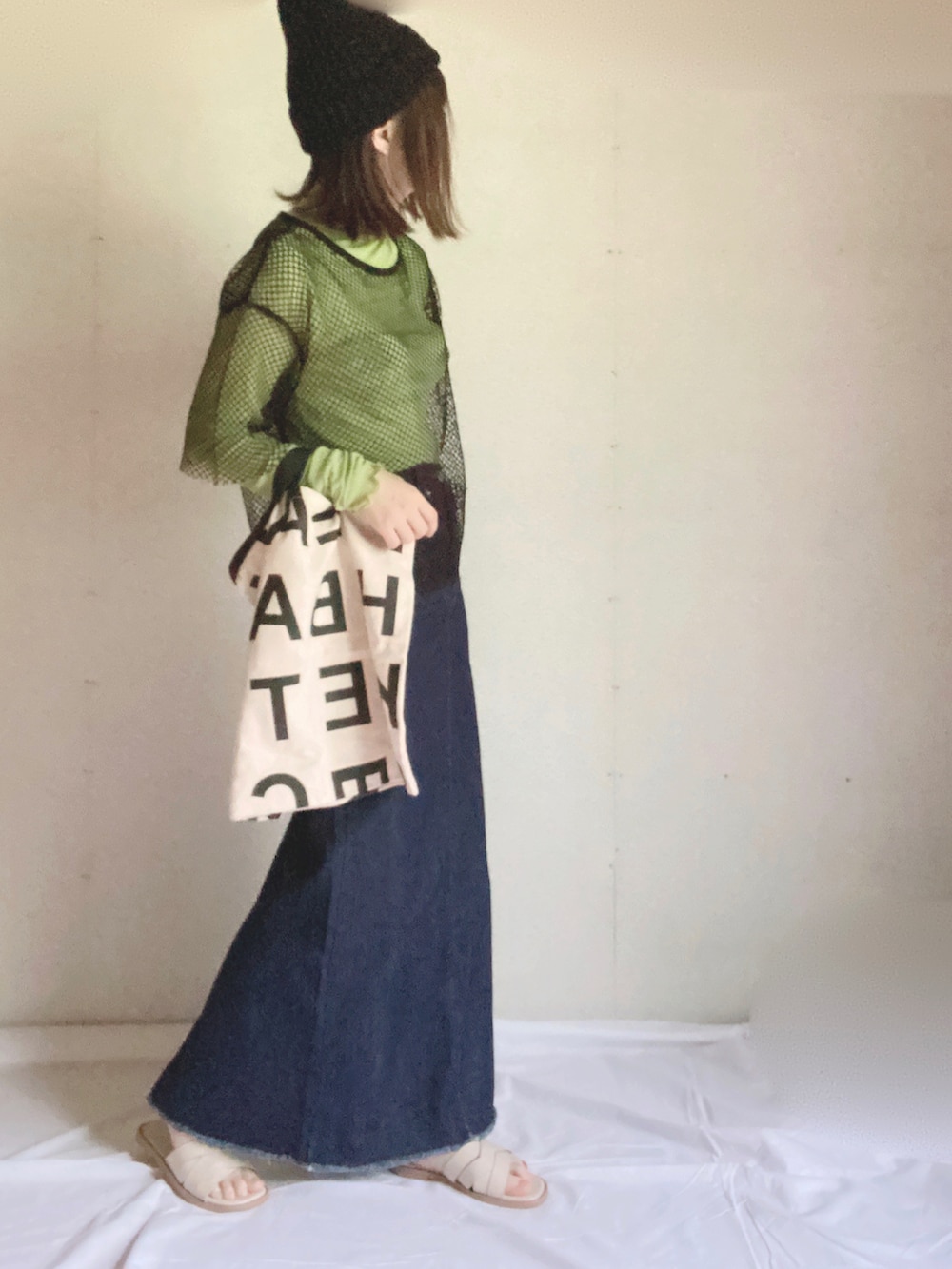 ブルー系のデニムスカート、ホワイト系のサンダル、グリーン系のTシャツ/カットソーを着用したレディースの秋コーディネートの4枚目の写真