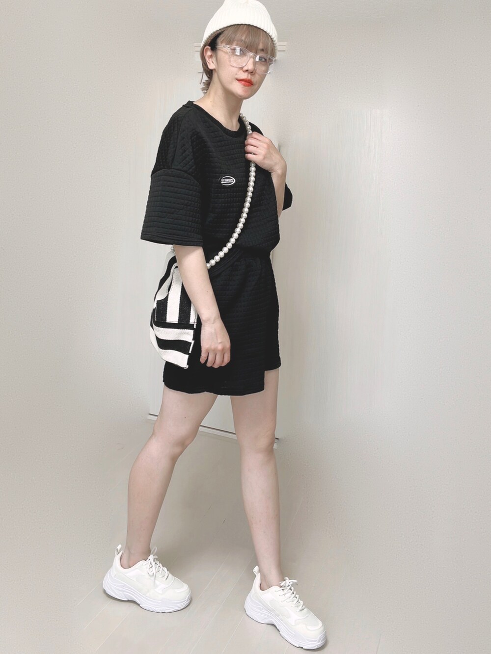 ホワイト系のショルダーバッグ、ホワイト系のスニーカー、ホワイト系のニットキャップ/ビーニーを着用したレディースの夏コーディネートの4枚目の写真