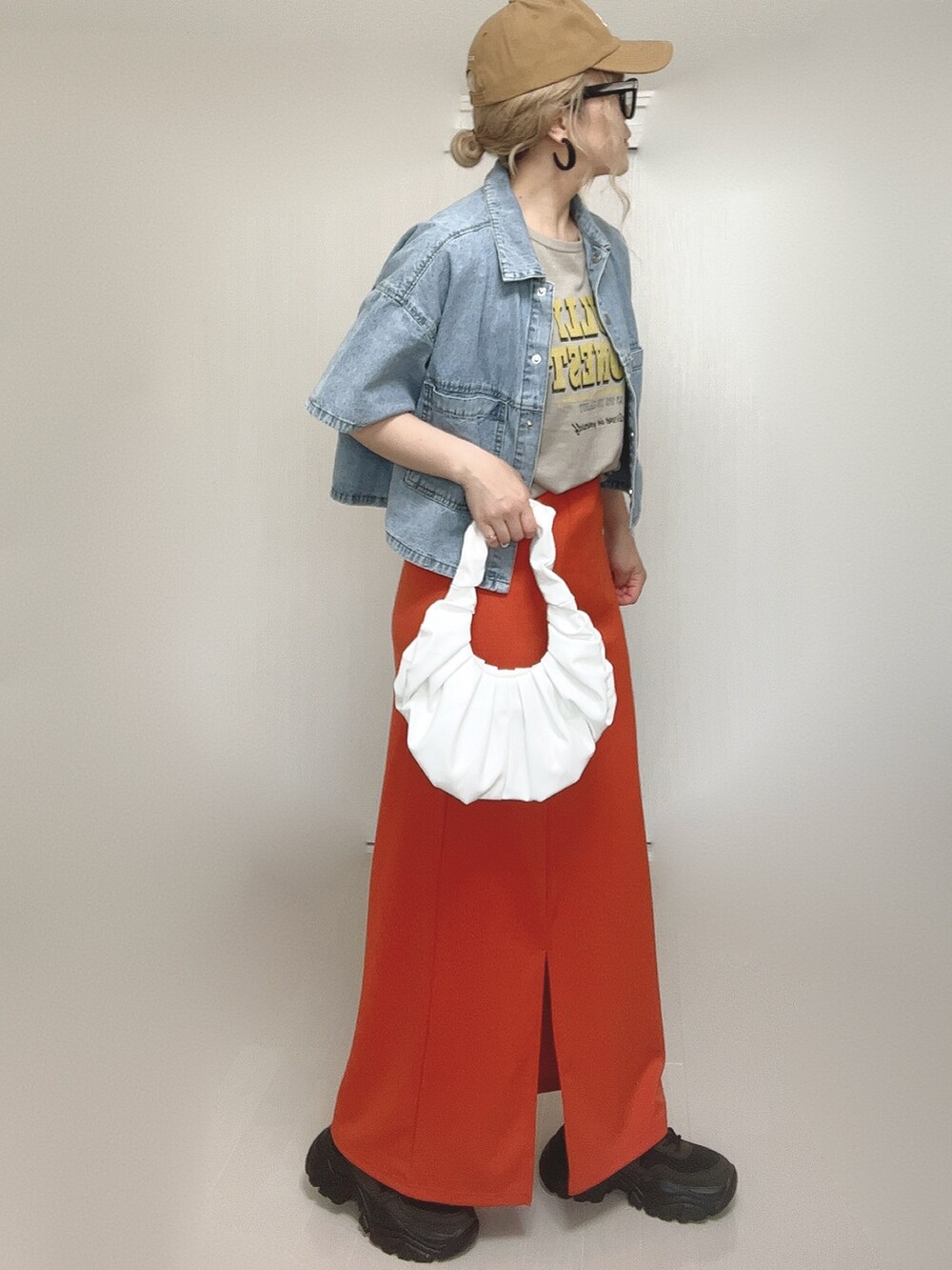 ブルー系のシャツ/ブラウス、オレンジ系のスカート、ブラック系のスニーカーを着用したレディースの夏コーディネートの3枚目の写真