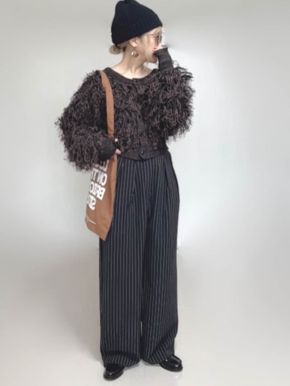 ブラック系のカーディガン/ボレロ、ブラック系のスラックス、ブラック系のローファーを着用したレディースの秋コーディネートの2枚目の写真