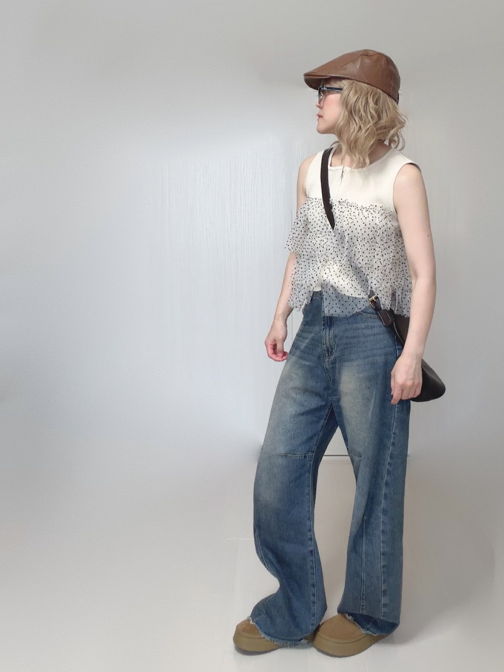 ブルー系のデニムパンツ、ホワイト系のニット/セーター、ベージュ系のシューズを着用したレディースの夏コーディネートの2枚目の写真