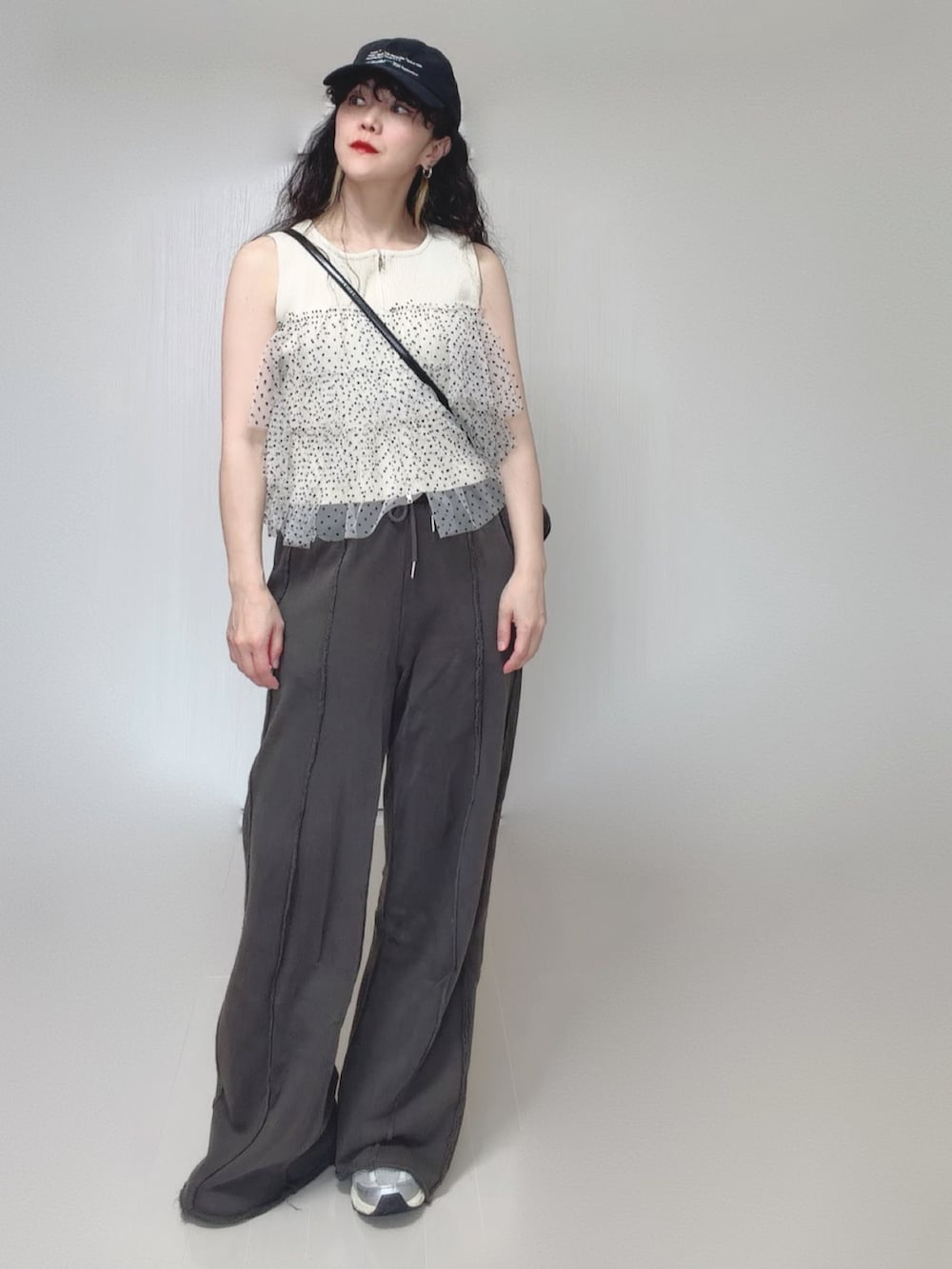 ホワイト系のニット/セーター、ブラック系のスウェットパンツ、ブラック系のボストンバッグを着用したレディースの夏コーディネートの3枚目の写真
