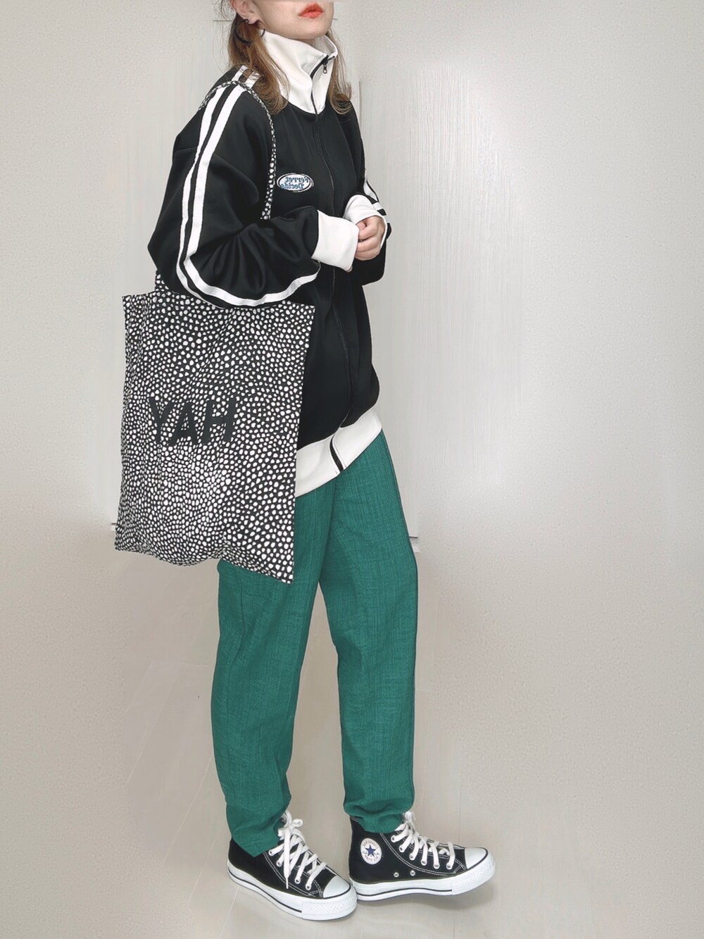 ブラック系のブルゾン、グリーン系のその他パンツ、ブラック系のスニーカーを着用したレディースの秋コーディネートの2枚目の写真