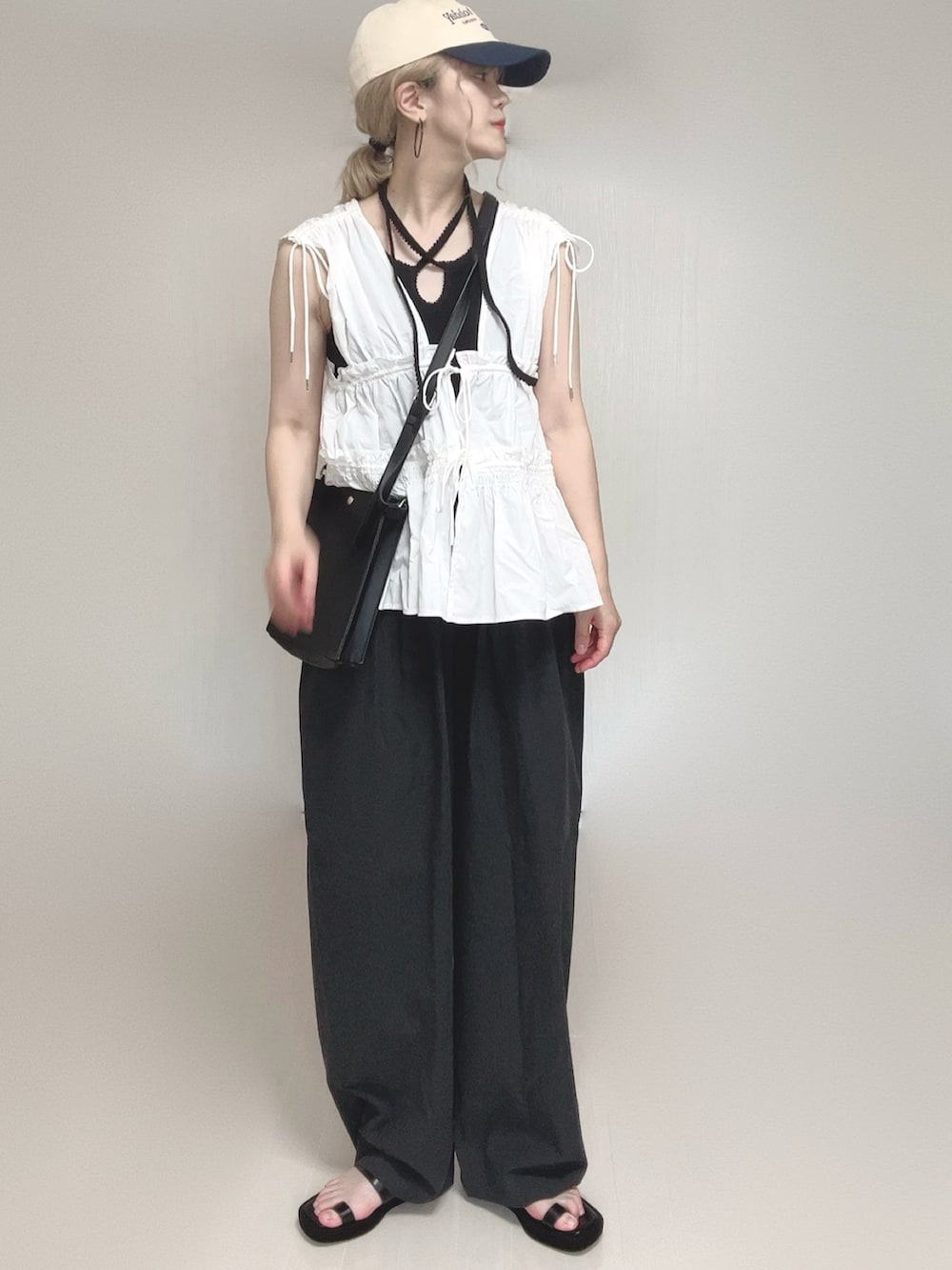 ホワイト系のシャツ/ブラウス、ブラック系のサンダル、ブラック系のタンクトップを着用したレディースの夏コーディネートの5枚目の写真